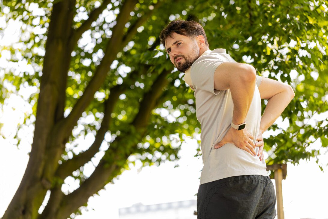 Young runner man suffering from back pain sports injury muscle spasm flank ache in city park | SoloSalud.net