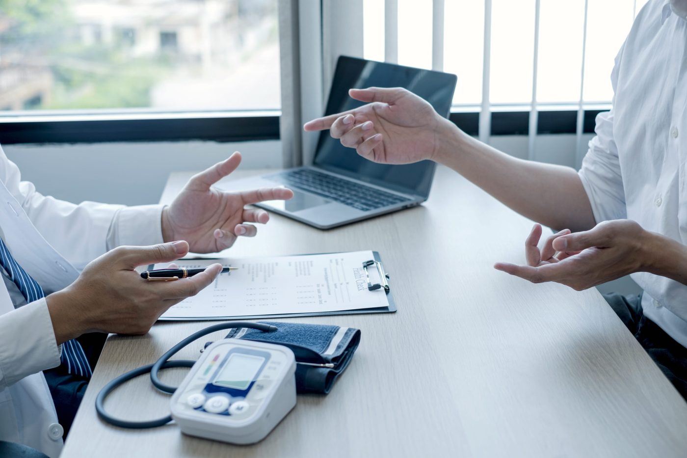 Burn out medicina familiar - IP | SoloSalud.net Two professionals review medical forms on a desk, with a blood pressure monitor and laptop visible.