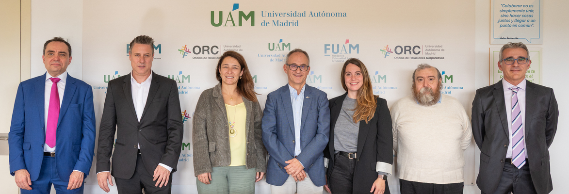 Biosmartdata - FUAM - IP | SoloSalud.net Eight professionals in business attire pose for a group photo in front of a UAM backdrop with logos of Universidad Autónoma de Madrid.