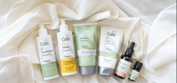 Assorted Cutis hemp seed oil skincare products arranged on a white fabric background, ready for use or display.