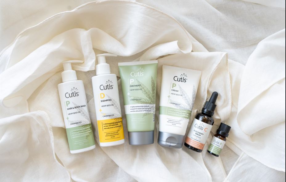 Assorted Cutis hemp seed oil skincare products arranged on a white fabric background, ready for use or display.