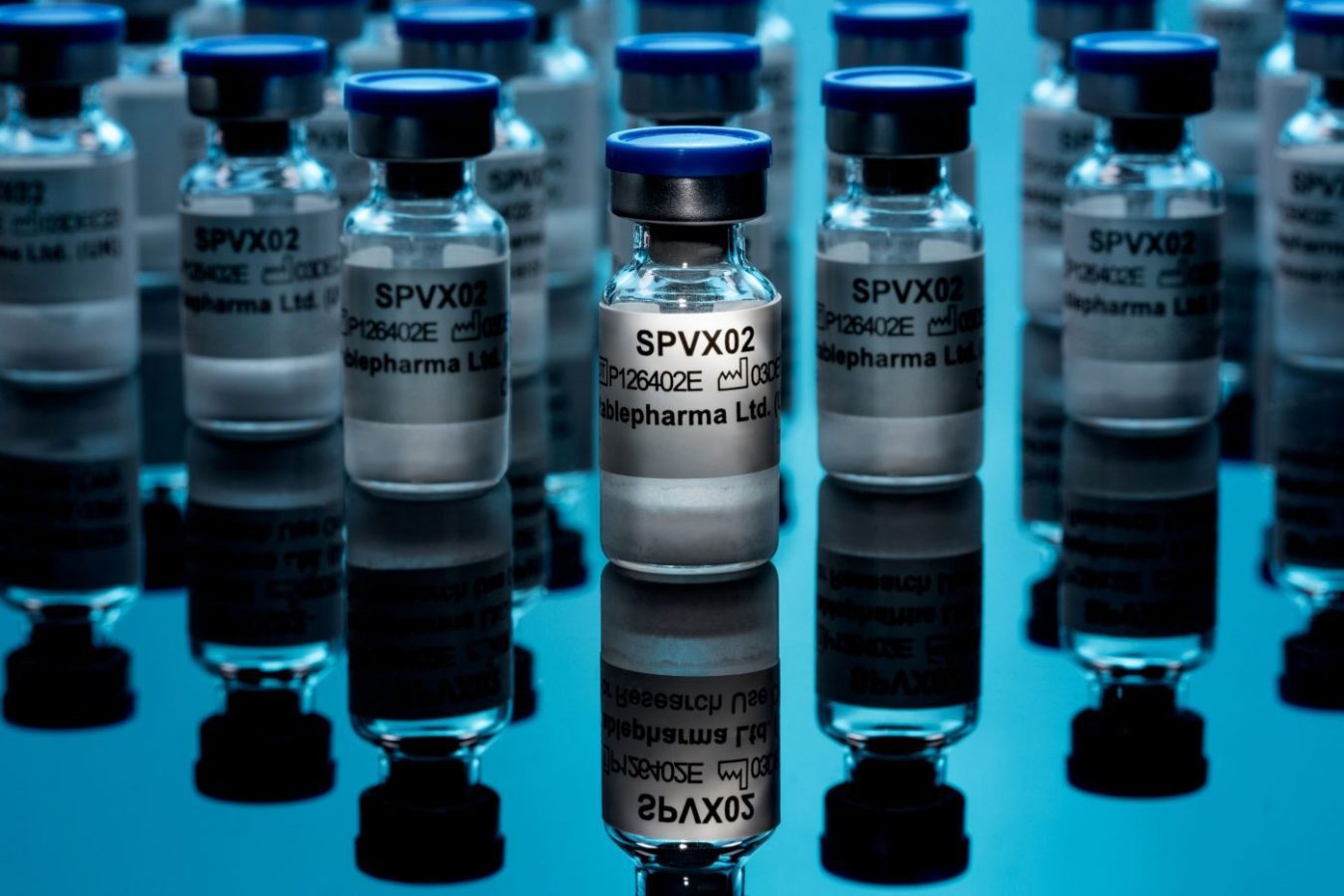 Stablefarma - Vacuna - IP | SoloSalud.net Multiple glass vials labeled SPVX02 on a reflective blue surface, suggesting a pharmaceutical or vaccine production scene.